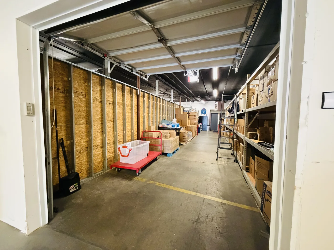 The Kindness Closet's Mooresville warehouse before the renovation, with stock on shelving along one side