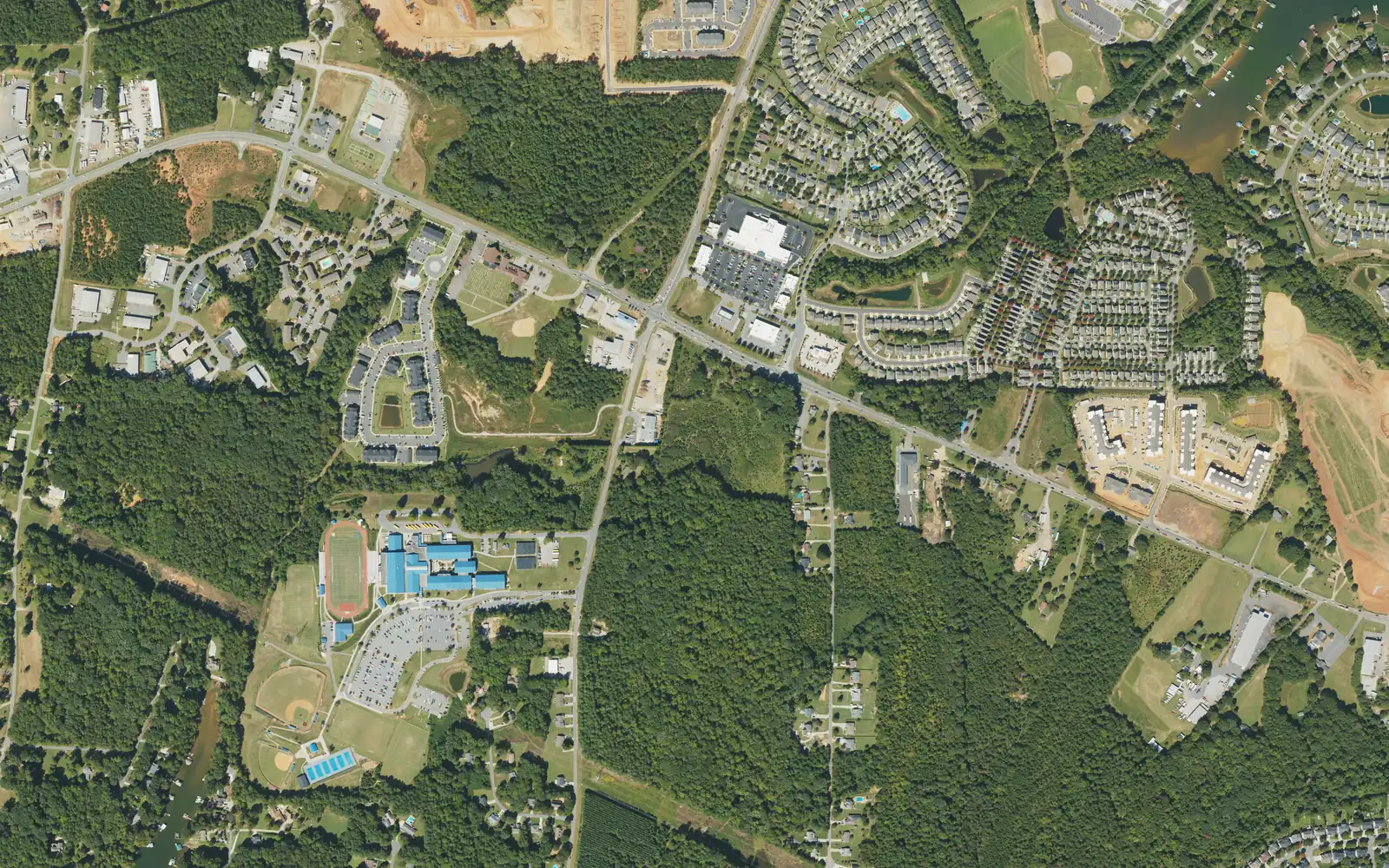 Aerial view of the Doolie area west of I-77, with Lake Norman High School's campus and track at lower left, River Highway (N.C. 150) crossing the middle and subdivisions near Lake Norman at upper right