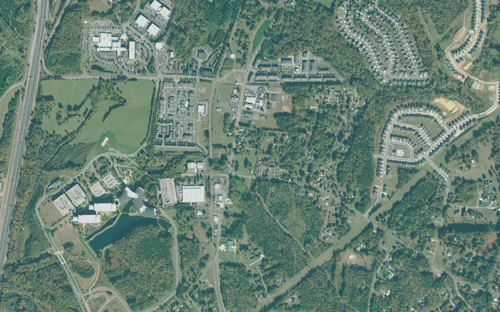 Aerial view of the Mount Mourne area, with I-77 at left, an office campus and pond at lower left and older homes and new subdivisions along the roads to the east