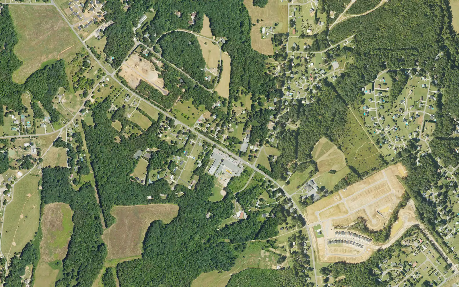 Aerial view of Shepherds, north of Mooresville, with Charlotte Highway running diagonally past Shepherd Elementary School, farm fields and a new subdivision under construction at lower right