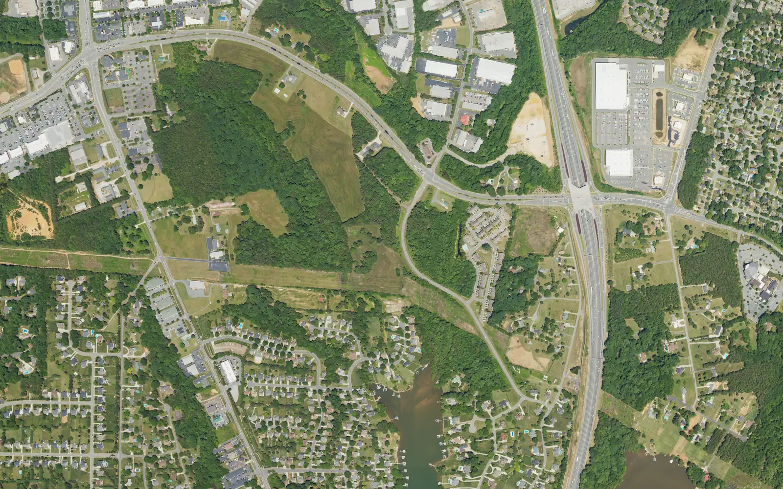 Aerial view of the Williamson Road area west of I-77, with the Brawley School Road interchange at right, shopping centers along the roads and lakeside neighborhoods at the bottom