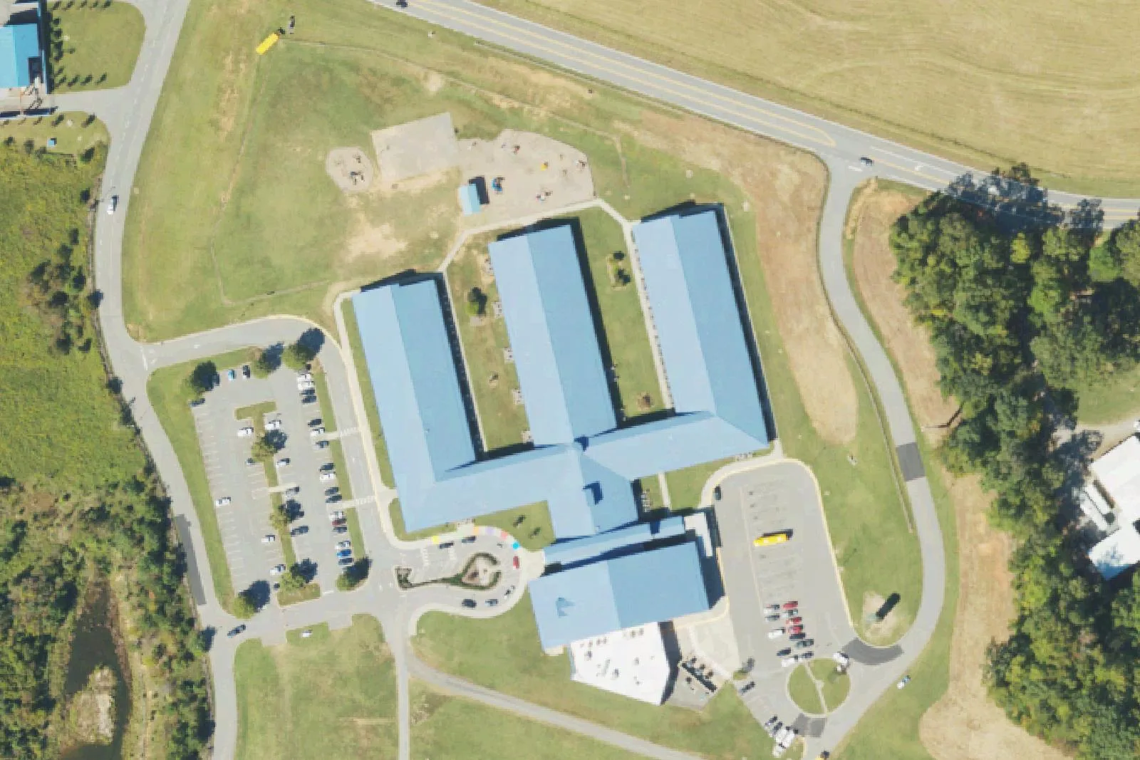 Coddle Creek Elementary School's blue-roofed classroom wings and parking lots on Frank's Crossing Loop in Mooresville, seen from the air