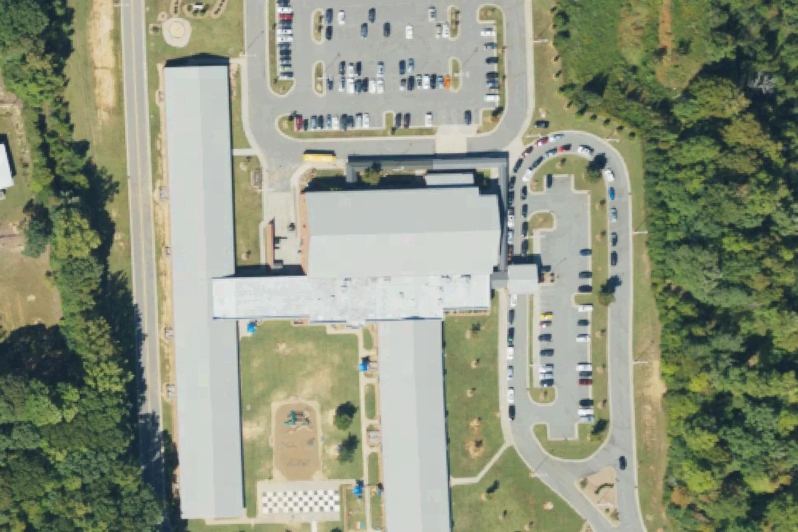 Rocky River Elementary School's long classroom building and parking lots on Rocky River Road in Mooresville, seen from the air