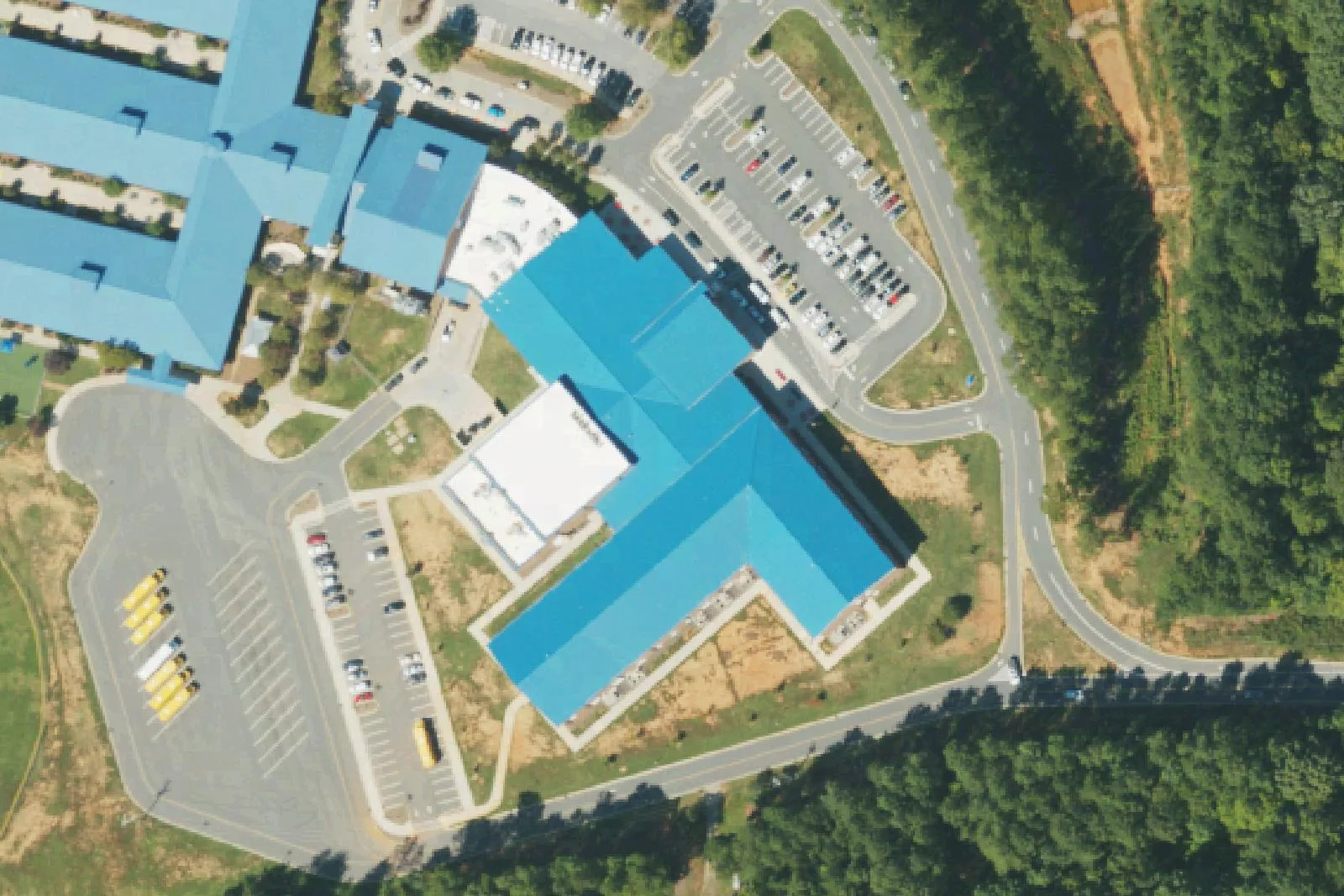 Woodland Heights Middle School's blue-roofed building, gym and bus lot on Forest Lake Boulevard in Mooresville, seen from the air