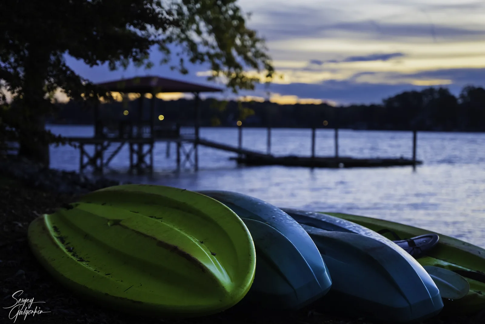 Kayaks pulled up beside a dock on Lake Norman at dusk