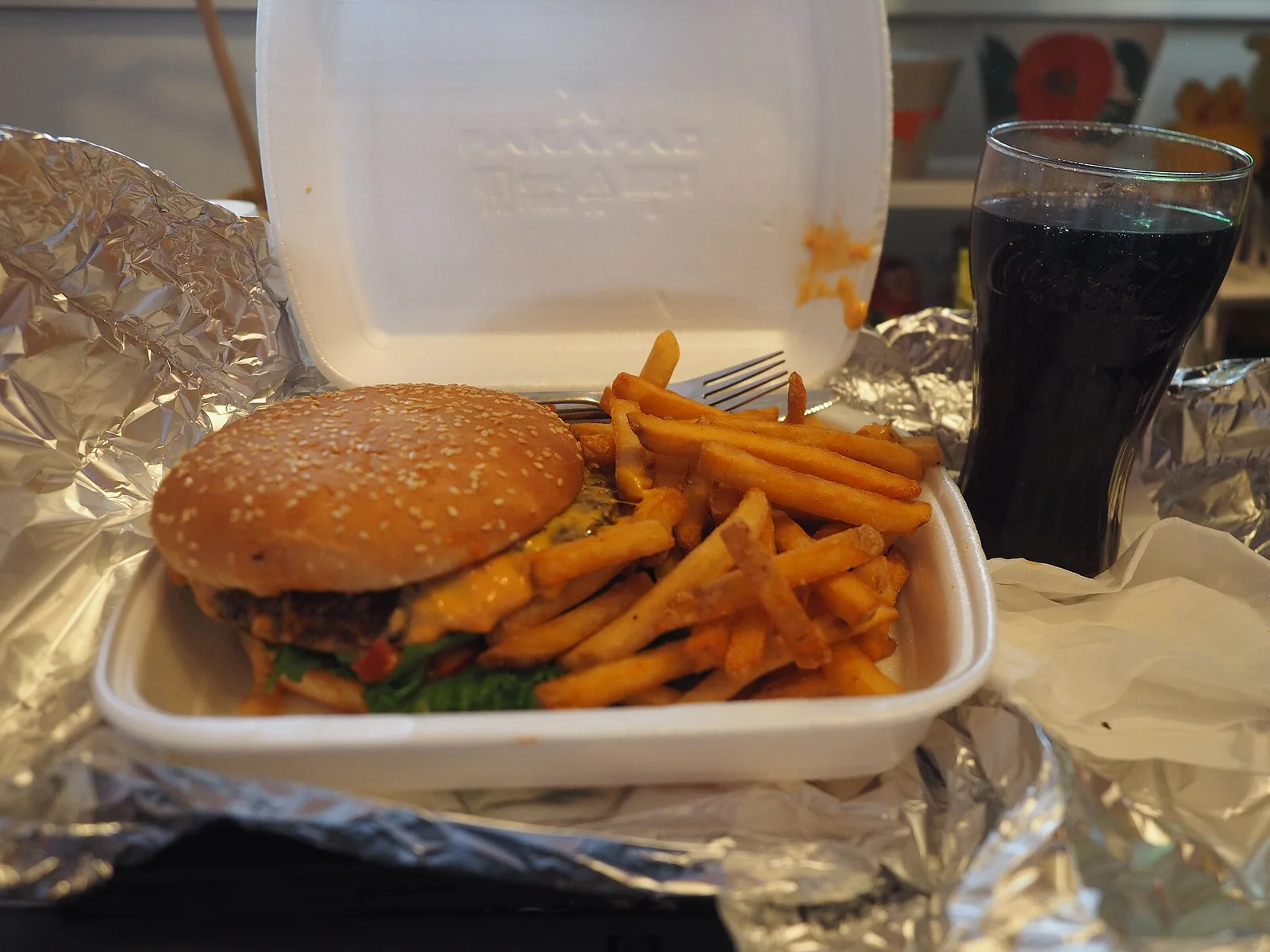 A cheeseburger and fries in a takeout box, with a cola. The photo was not taken at a Mooresville restaurant.