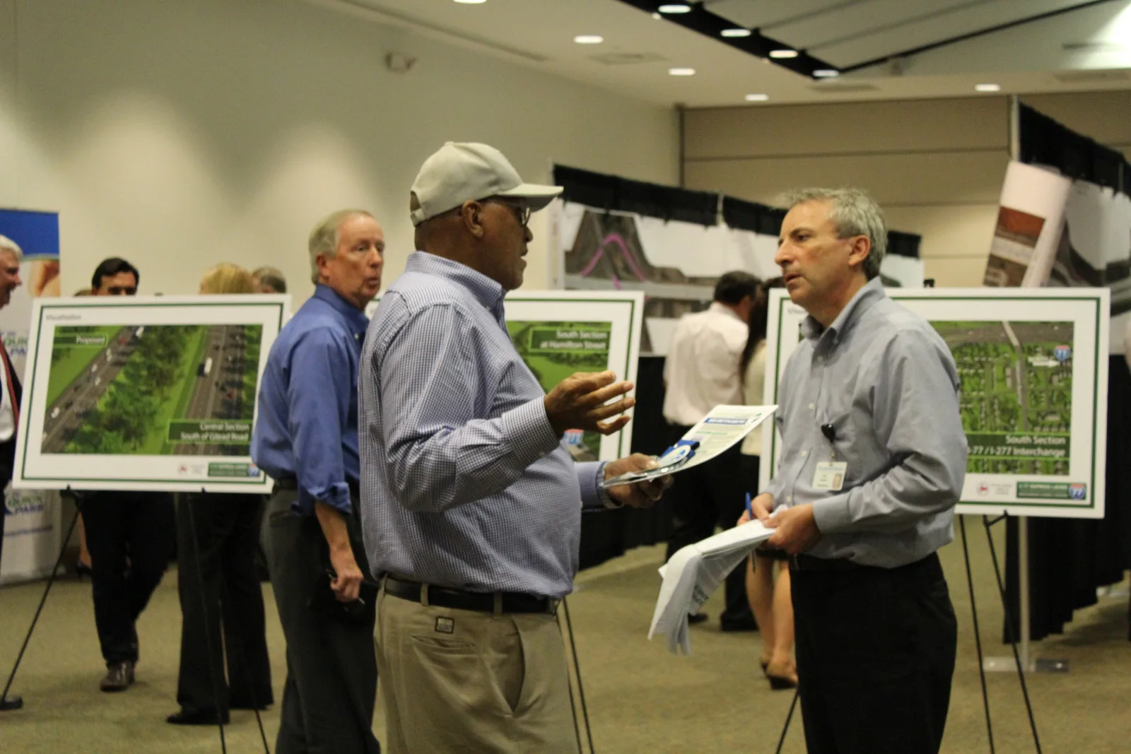 Visitors talk in the main hall of the Charles Mack Citizen Center, the craft show's home, during a public meeting in Mooresville